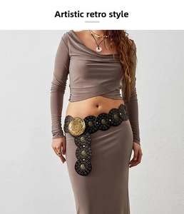 Detail of bohemian retro belt with black hollow metal discs and antique bronze engraving