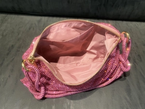 Macro view of the pink rhinestone handbag interior showing fabric lining and card pockets