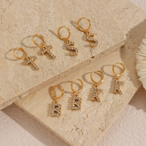 Detail of 18K gold plated hoop earrings with micro-set zircon letters and cross charms