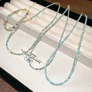 Light blue natural stone and pearl necklace set with gold plating on a jewelry tray