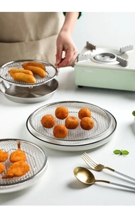 Detail of stainless steel cooling rack and tray set with crispy fried food on the counter
