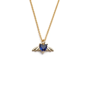 Gold angel wing pendant necklace featuring a deep blue heart-shaped gemstone on white