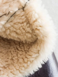 Macro shot of soft cream faux shearling lining showing thick and warm fleece texture