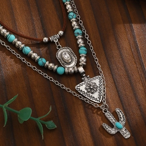 Detail van Boheemse gelaagde ketting met hangers van turquoise cactus en cowboyhoed