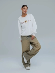 Λευκό oversized φούτερ με τύπωμα και χαλαρό καφέ τζιν παντελόνι με φαρδύ μπατζάκι