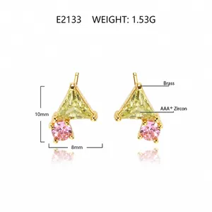 Macro shot of geometric brass studs featuring yellow triangle and pink round zircons