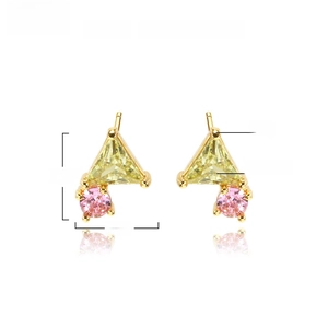 Macro shot of geometric brass studs featuring yellow triangle and pink round zircons