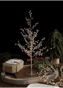 Golden crystal beaded mini Christmas tree decor with sparkling diamonds on a festive table