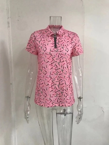 Detail of pink polo shirt featuring half-zip neckline and golf tee geometric print