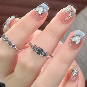 Short French style press-on nails with blue gradient, glitter, and heart charms with rings