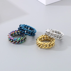 Detailed close-up of Cuban link chain rings in gold, silver, blue, and rainbow titanium steel