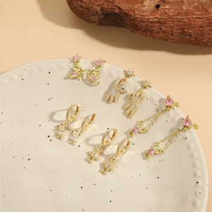 Vintage bear and star stud earrings with pink zircon set on a white ceramic plate