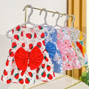 Detail of four pet dresses with floral prints and large bows on pearl hangers