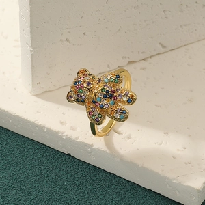 Chic gold teddy bear ring pavé set with vibrant colorful crystals on a marble base