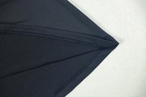 Detail of double-needle stitching and smooth black fabric texture on bodycon dress