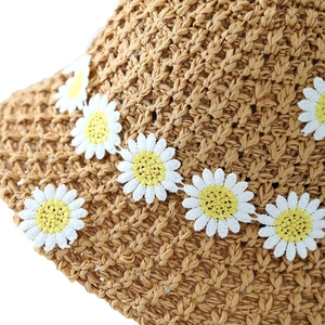 French vintage straw bucket hat with colorful woven texture and daisy flower accents