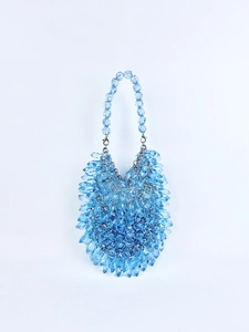 Close-up of blue acrylic beads with textured weaving and lobster clasp on evening bag