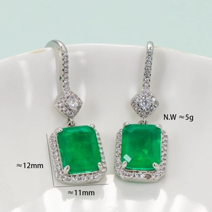 Elegant emerald green zircon earrings with silver frame shown from a front angle view