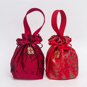 Detail of red brocade wedding candy bags with gold Double Happiness charms and silk bows