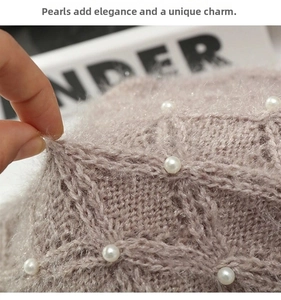 Dettaglio macro della maglia rosa a rombi con perle e morbida consistenza felpata