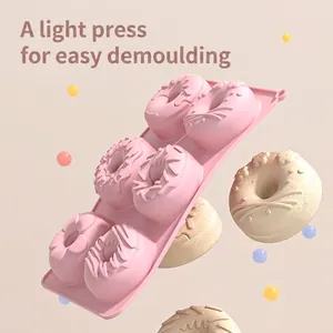 Pink 6-cavity silicone donut mold with various shapes and finished baked treats