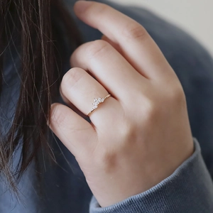Detailed view of a gold princess crown ring with marquise white stones on a model hand
