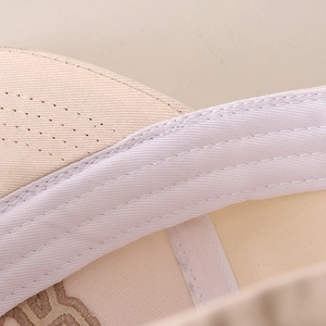 Macro shot of durable cotton stitching and sweatband details on beige baseball cap