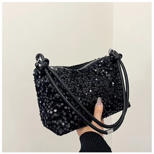 Detailed view of the black sequined baguette bag showing reflective texture and zipper