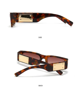 Detail of tortoise shell rectangular sunglasses with large gold metal side plates