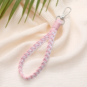 Close-up of pink and white braided cotton keychain with silver lobster clasp on texture