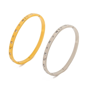 Detail view of gold and silver stainless steel star bangles with zircon inlay