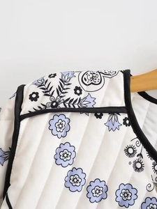 Macro shot showing quilted floral fabric details and black contrast trim on women jacket
