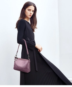 Purple faux crocodile skin shoulder bag with metal hardware shown on elegant model