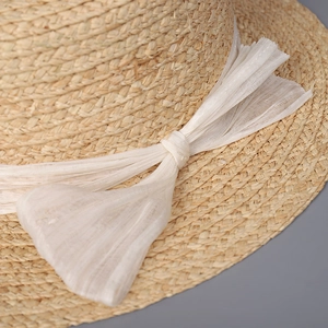 Natural raffia straw boater hat with a delicate white silk bow ribbon for summer
