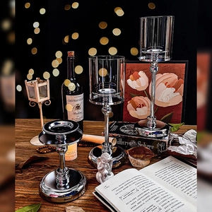 Three-piece silver metal candle holders with glass covers for elegant dinner table decor