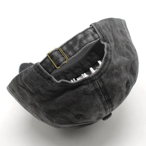 Detail of adjustable brass buckle and vintage washed fabric on charcoal baseball cap