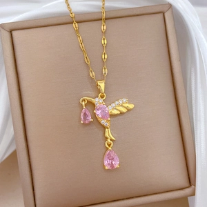 Detailed view of hummingbird pendant with pink gemstones and crystals on golden chain