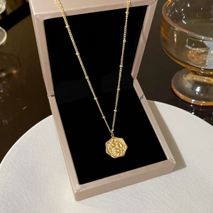 Detailed macro view of a gold-plated butterfly necklace inside a premium jewelry box