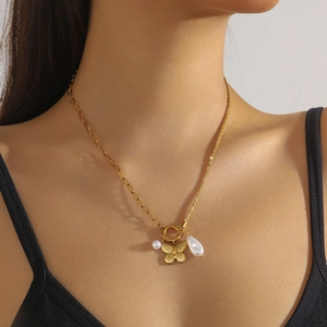 Gold butterfly pendant necklace with baroque pearls and T-bar toggle clasp on model