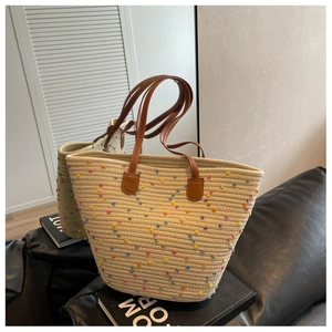 Close-up of woven cotton tote bag with colorful polka dots and brown leather handles