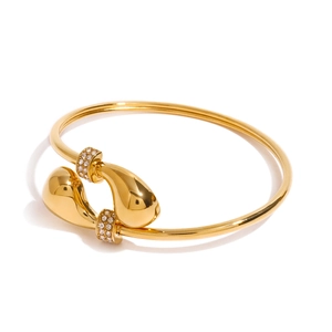 Gepolijste gouden roestvrijstalen open armband met in elkaar grijpende druppels en pavé kristallen