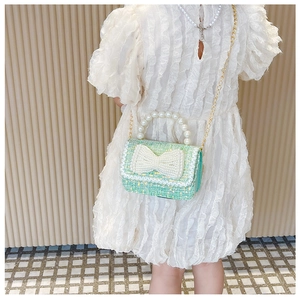 Fillette portant un sac bandoulière en tweed vert clair avec poignée en perles et nœud
