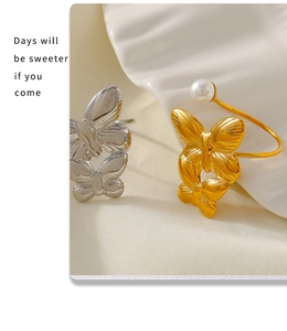 Detail of adjustable butterfly rings in gold and silver finish with pearl embellishment