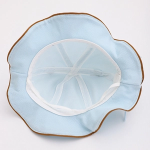 Detail of baby sun hat with light blue fabric, brown trim and soft breathable lining