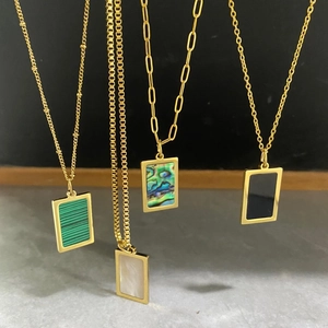 Detalle de collares chapados en oro con incrustaciones de concha y piedra malaquita