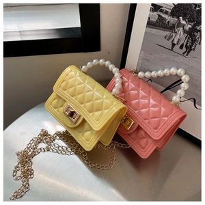 Detail of quilted jelly bags with faux pearl handles and golden chain straps