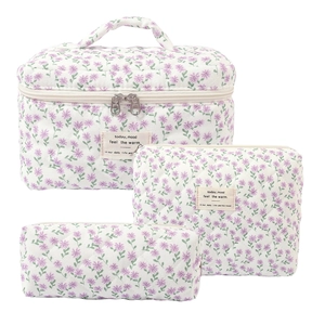 Three-piece quilted cotton makeup bag set with purple floral pattern in white