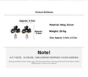 Détail de boucles d'oreilles fleurs noires avec des pendentifs en zircon en forme de goutte