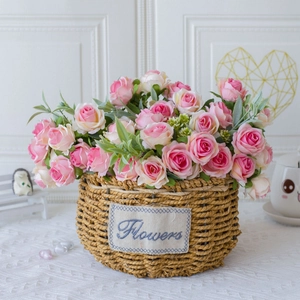 Pink and white artificial silk roses in a woven basket for home and wedding decor