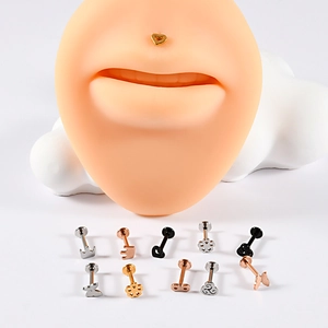 Selection of stainless steel labret piercings in gold, silver, and rose gold on white backdrop